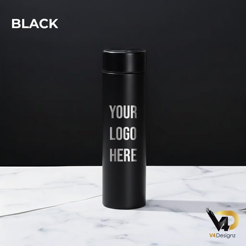 K&ouml;nnte beinhalten: Schwarze isolierte Wasserflasche mit silbernem "YOUR LOGO HERE" Design. Das Wort "BLACK" steht oben links. Die Flasche ist zylindrisch mit schwarzem Deckel. Der Hintergrund ist schwarz und die Oberfl&auml;che ist wei&szlig;er Marmor.