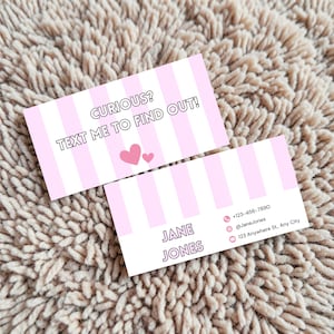 Op de afbeelding: Twee visitekaartjes met een roze en witte streepjespatroon. De bovenste kaart leest "CURIOUS? TEXT ME TO FIND OUT!" met twee roze hartjes. De onderste kaart toont "JANE JONES" en contactgegevens.