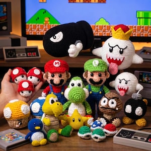 Könnte beinhalten: Eine Sammlung verschiedener gehäkelter Plüschfiguren, inspiriert von Videospielcharakteren, darunter eine schwarze Kugel, ein weißer Geist mit Krone, Mario, Luigi, ein grüner Dinosaurier, ein brauner Pilz, ein gelber Stern und mehrere kleine bunte Panzer.