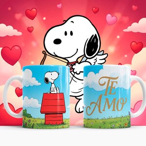 May include: Two white ceramic mugs with Snoopy designs. One mug features Snoopy on his doghouse, the other has "Te Amo" in gold script. The background is a sky with clouds and hearts.
