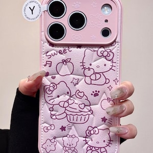 Op de afbeelding: Roze telefoonhoesje met een cartoonontwerp van Hello Kitty-personages, cupcakes en sterren. De hoes heeft een gestructureerd oppervlak en het woord "Sweet". De hoes heeft uitsparingen voor de camera en knoppen van de telefoon.