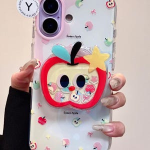 May include: Clear phone case with a colorful design. The case features a large, red apple with a yellow star and the text "Sweet Apple". The background has small apple and bow graphics.
