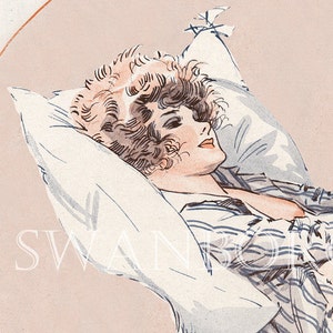 May include: A woman with curly brown hair lies on a white pillow wearing a light blue and white striped shirt. The background is a light pink colour.