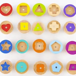 May include: Wooden shape sorter toy with 20 colorful pieces. Each piece is a different shape, including hearts, squares, triangles, crosses, hexagons, stars, circles, and pentagons. The shapes are painted in bright colors like red, yellow, green, blue, orange, and purple.