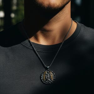 Close up st michael necklace showing high relief engraving, textured background and gold wings, durable 316L steel christian necklace with strong catholic jewelry presence.