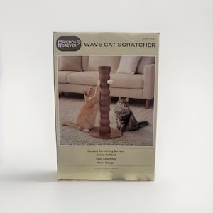 May include: A cardboard product box for a Friends Forever Wave Cat Scratcher. The box features a brown, cylindrical, wave-textured scratching post with a white catnip puffball, shown with an orange cat and a grey cat. Text includes dimensions 15 in x 12.6 in.