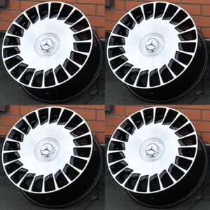 Peut inclure: Quatre jantes en alliage noir et argent. Chaque roue pr&eacute;sente un centre argent&eacute; avec un logo Mercedes-Benz et une jante ext&eacute;rieure noire. Les roues sont dispos&eacute;es en carr&eacute;, avec un design &agrave; plusieurs rayons.