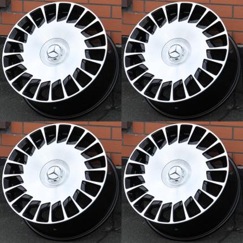 Peut inclure: Quatre jantes en alliage noir et argent. Chaque roue pr&eacute;sente un centre argent&eacute; avec un logo Mercedes-Benz et une jante ext&eacute;rieure noire. Les roues sont dispos&eacute;es en carr&eacute;, avec un design &agrave; plusieurs rayons.