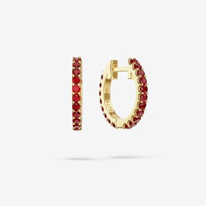 Könnte beinhalten: Ein Paar goldene Creolen, die auf der Vorderseite mit einer Reihe runder roter Edelsteine besetzt sind. Die Innenseite eines Ohrrings ist deutlich mit dem Text 14K CALTOR graviert, was die Metallreinheit und die Marke des Schmuckstücks angibt.