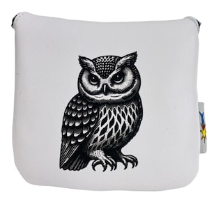 May include: White square golf club head cover featuring a detailed black and white illustration of an owl. The owl has intricate feather detailing and is centered on the cover. A small tag with a colorful design is attached to the side.
