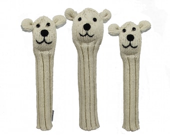 Puede incluir: Tres cubrecabezas de palo de golf de punto blanco con un diseño de cara de oso. Las caras de oso tienen ojos negros, una nariz negra y una boca negra.