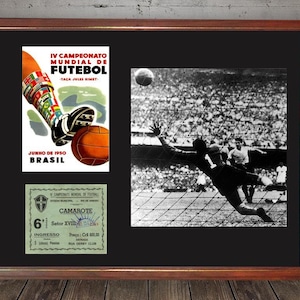Puede incluir: Enmarcado recuerdo de fútbol vintage. Incluye una foto en blanco y negro de un portero, un cartel colorido de la Copa del Mundo de 1950 en Brasil y una entrada. El marco es marrón.