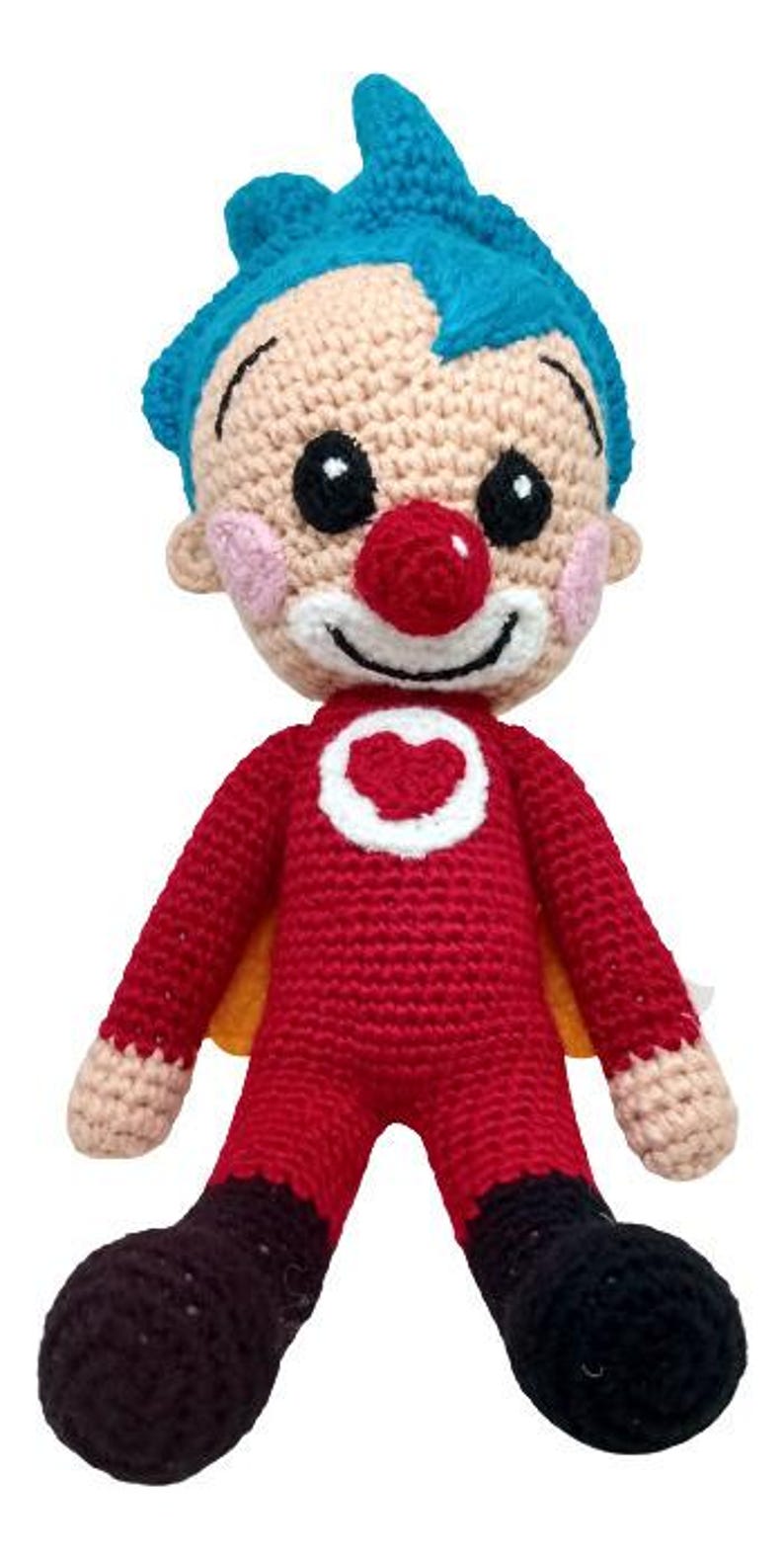 Pu&ograve; includere: Bambola pagliaccio all'uncinetto fatta a mano. La bambola ha un viso beige con capelli blu, un naso rosso e un sorriso bianco. Indossa un completo rosso con un cuore bianco e scarpe nere.