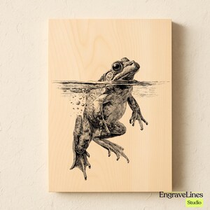 May include: A black and white illustration of a frog in water, printed on a light wood panel. The frog is partially submerged, with bubbles visible underwater. The artwork is signed "EngraveLines Studio".