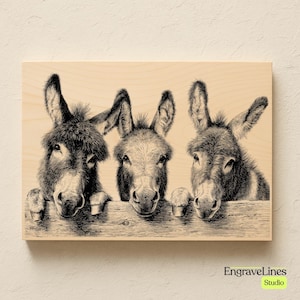 May include: A wooden wall art piece featuring a detailed black and white illustration of three donkeys peeking over a wooden fence. The artwork has a natural wood grain background and the text "EngraveLines Studio" in the bottom right corner.