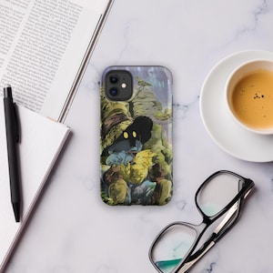 May include: A phone case featuring a colorful illustration of a fantasy character with a black hat and yellow accents. The case is on a white marble surface, next to a cup of coffee, a pair of glasses, and an open book.