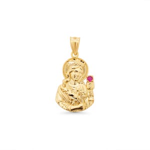 Può includere: Ciondolo in oro raffigurante un santo con corona e aureola. Il ciondolo presenta una gemma rossa ed è sospeso da un'ansa in oro. Il design è dettagliato e il ciondolo è probabilmente in oro. Un oggetto religioso.