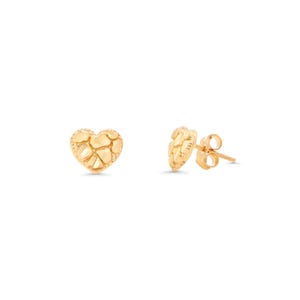 May include: Two gold-colored heart-shaped stud earrings. The earrings have a textured surface, giving them a unique, organic appearance. The studs are set against a plain white background.