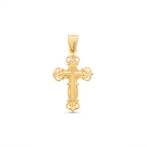Könnte beinhalten: Ein goldfarbener Anhänger in Form eines Kreuzes. Das Kreuz hat ein verziertes Design mit gerollten Kanten und einer strukturierten Oberfläche. Der Bügel ist ebenfalls goldfarben und oben am Kreuz befestigt.
