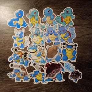 May include: A collection of sixteen die-cut vinyl stickers featuring various stages of the blue turtle-like creature evolution. The designs display the characters in different poses, including some with water cannons, shells, and dynamic action stances.