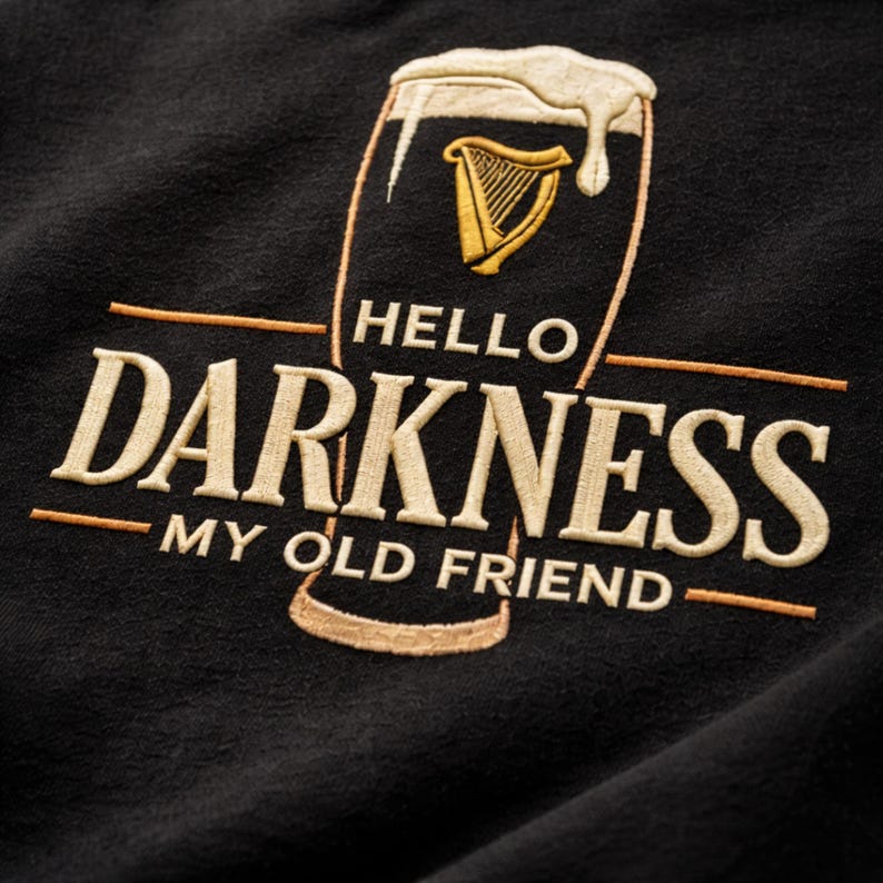 May include: Black sweatshirt with embroidered design. The design features a pint of stout with a harp symbol and the words "HELLO DARKNESS MY OLD FRIEND" in cream-colored thread.