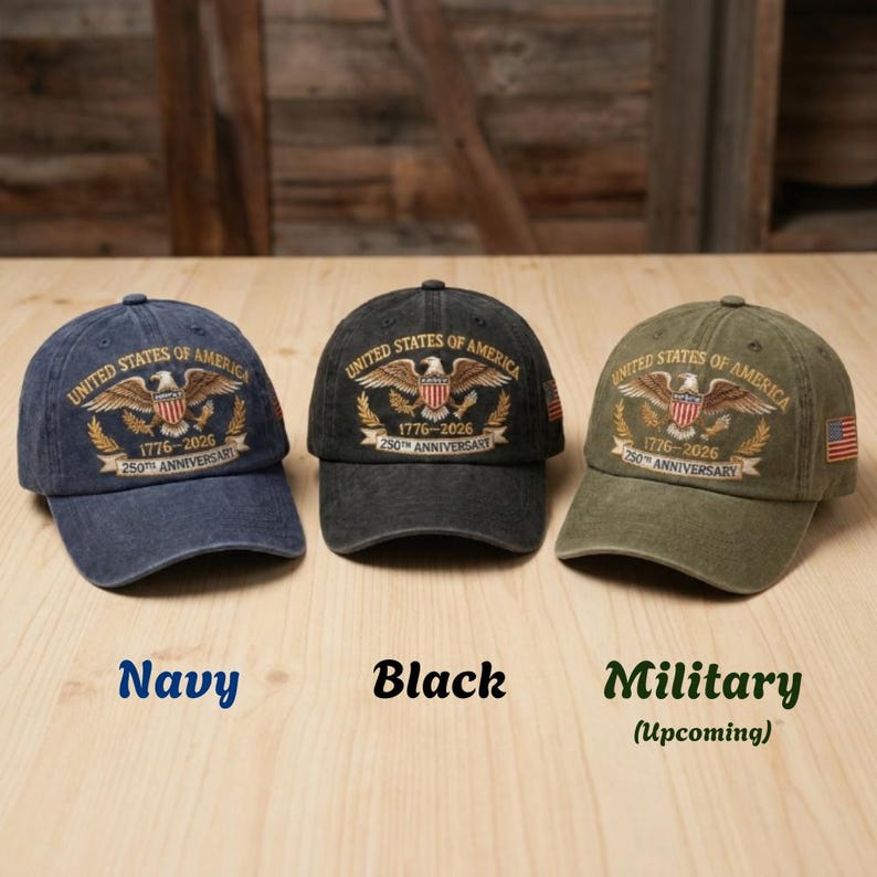 Puede incluir: Tres gorras de b&eacute;isbol en azul marino, negro y verde militar. Cada gorra presenta un dise&ntilde;o bordado con un &aacute;guila, el texto "UNITED STATES OF AMERICA" y "1776-2026 250th ANNIVERSARY". Los colores de las gorras est&aacute;n etiquetados abajo.