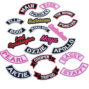 May include: A collection of embroidered patches in various shapes and colors. The patches feature names and phrases like "MAUI", "BASIL", "FOREVER", and "STAFFY". The patches have a black border with white or colored text.