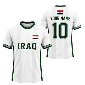 May include: White soccer jersey with green trim and the word "IRAQ" in green block letters. The jersey features the Iraqi flag and the number 10 on the back, with space for a name. The sleeves have a decorative green pattern.