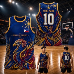 以下が含まれることがあります： 赤、黄、青の大きなフェニックスのグラフィック、PHILIPPINESの文字、フィリピン国旗がデザインされた青いバスケットボールジャージ。背面にはYOUR NAMEの文字と背番号10が、詳細なフェニックスのイラストの上にプリントされています。