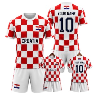 May include: A set of Croatia soccer jerseys in red and white checkered pattern. The jerseys have the word "CROATIA" printed on the front and the Croatian flag. One jersey has the number 10 and "YOUR NAME" on the back.