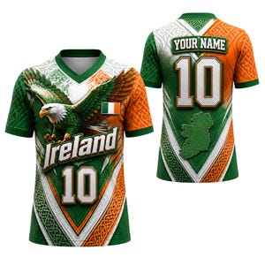 Könnte beinhalten: Ein kurzärmeliges V-Ausschnitt-Trikot in den Farben Grün, Weiß und Orange. Die Vorderseite zeigt einen Weißkopfseeadler, den Schriftzug Ireland und die Nummer 10. Die Rückseite zeigt den Text YOUR NAME, die Nummer 10 und eine Karte von Irland.