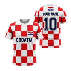 May include: A white and red checkered Croatia soccer jersey with the word "CROATIA" printed on the front. The jersey has a Croatian flag on the chest and the back features the number 10 and the text "YOUR NAME".