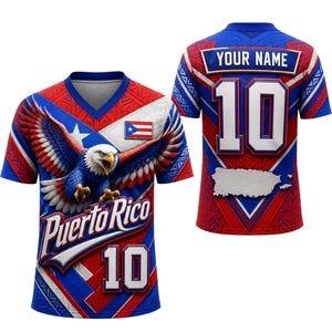 Può includere: Una maglia a maniche corte con scollo a V raffigurante un'aquila calva, la scritta Puerto Rico e il numero 10 sul davanti. Il retro mostra il testo YOUR NAME, il numero 10 e la sagoma di Porto Rico, il tutto nei colori rosso, bianco e blu.