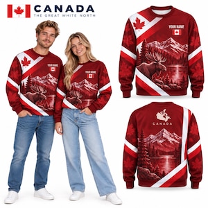 May include: A red and white long-sleeve sweatshirt featuring a Canadian flag, a moose in a mountain landscape, and maple leaf patterns. The front includes a placeholder for a name, while the back displays a map of Canada and the text CANADA.