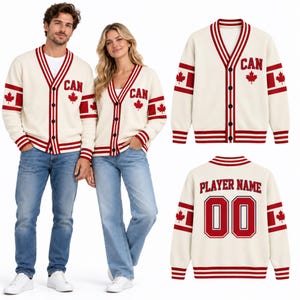 May include: An off-white V-neck cardigan with red striped trim, featuring the text CAN and a red maple leaf on the chest. The sleeves have red stripes and maple leaf accents. The back displays the text PLAYER NAME above the number 00.