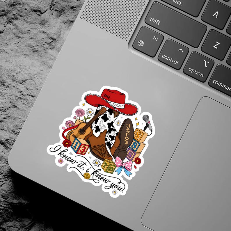 Puede incluir: Una pegatina con un sombrero de vaquero rojo, una guitarra ac&uacute;stica marr&oacute;n, una bota con estampado de vaca, un micr&oacute;fono y bloques de letras con el texto '13' y 'SSS'. El texto 'I knew it, i knew you.' aparece en cursiva negra abajo.