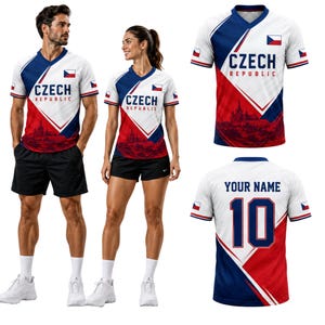 May include: A white, red, and blue V-neck sports jersey featuring the text CZECH REPUBLIC, the Czech flag, and a cityscape graphic. The back of the jersey displays the text YOUR NAME and the number 10 in large blue font with red outlines.