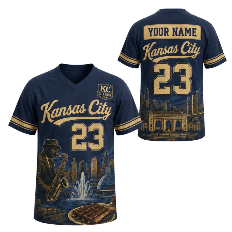 May include: Navy blue V-neck jersey with gold accents, featuring "Kansas City" and the number "23". The front displays a jazz musician, skyline, and BBQ. The back has "YOUR NAME" and a city skyline graphic.
