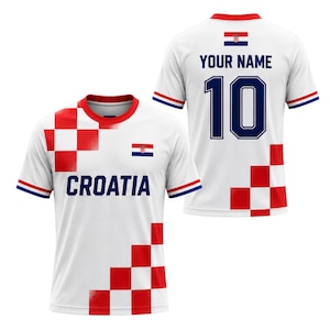 May include: White Croatia soccer jersey with red and white checkered design on the front and back. The front features the word "CROATIA" and the Croatian flag. The back has the number 10 and space for a name.