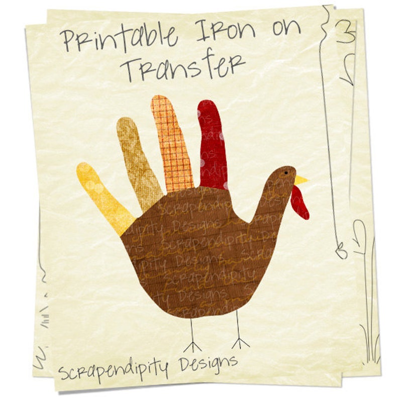 May include: Printable iron-on transfer featuring a brown turkey with a handprint design. The turkey has a red wattle and yellow beak. The text "Printable Iron on Transfer" and "Scrapendipity Designs" is included in the image.