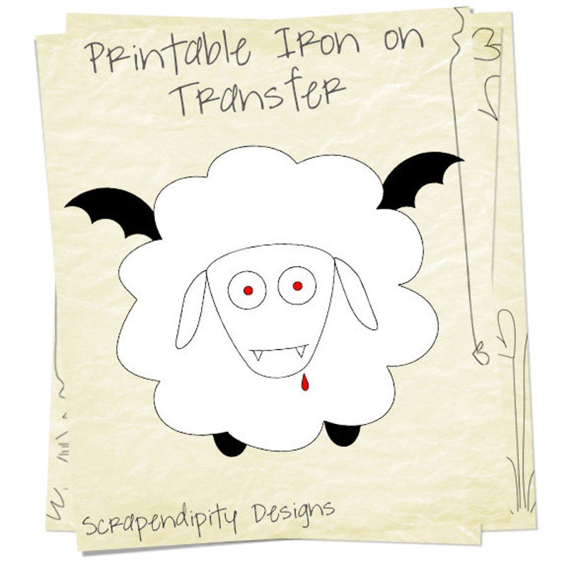 K&ouml;nnte beinhalten: Druckbarer B&uuml;geltransfer mit einem wei&szlig;en Schaf mit schwarzen Fledermausfl&uuml;geln, roten Augen und Z&auml;hnen. Der Text "Printable Iron on Transfer" befindet sich oben im Bild. Der Text "Scrapendipity Designs" befindet sich unten im Bild.