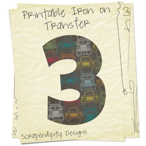 Pu&ograve; includere: Trasferimento da stirare stampabile con il numero 3 con un motivo di camion a pianale colorati su uno sfondo grigio scuro. Il testo "Printable Iron on Transfer" e "Scrapendipity Designs" &egrave; incluso.
