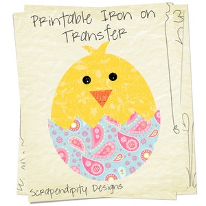 May include: Printable iron-on transfer design featuring a yellow chick peeking out of a blue and pink paisley patterned eggshell. The design says "Printable Iron on Transfer" and "Scrapendipity Designs".