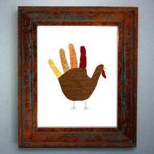 May include: A framed print of a handprint turkey craft. The turkey is made of brown, orange, yellow, and red paper. The turkey has a handwritten message on its body.