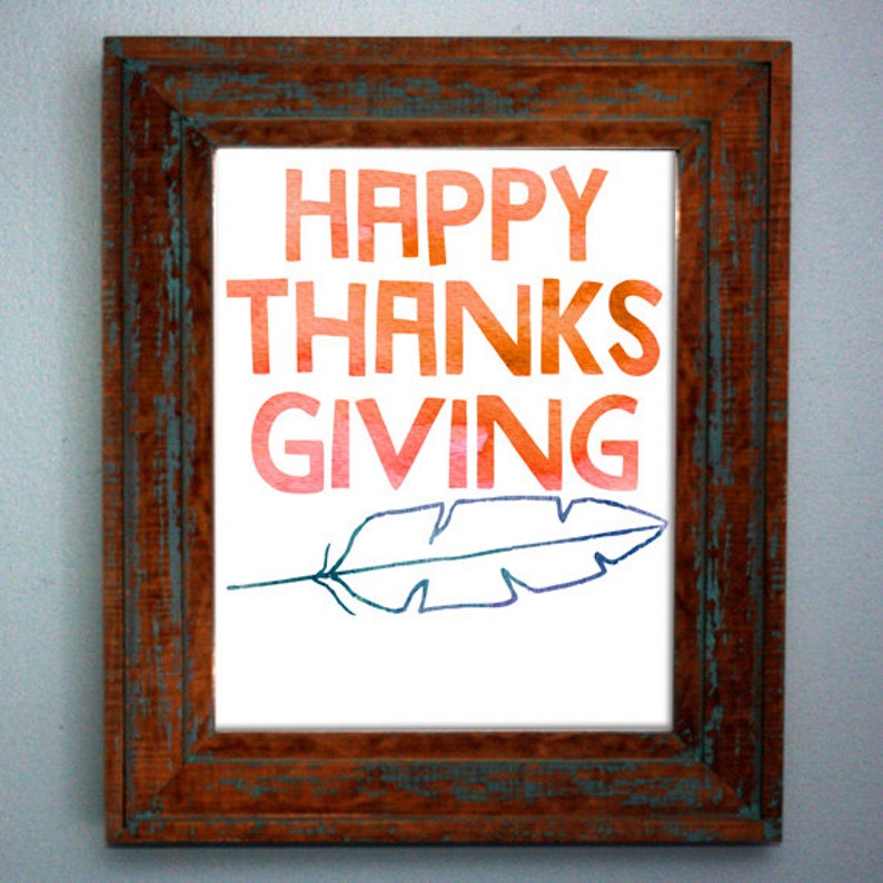 May include: A framed print with the text "HAPPY THANKSGIVING" in a gradient of orange, red, and pink. A blue and purple feather is drawn below the text.