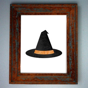 May include: A black witch hat with an orange band in a brown wooden frame.