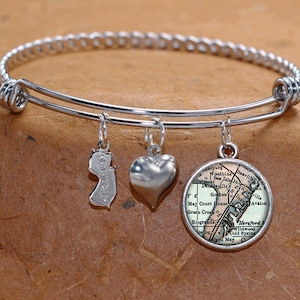 May include: A silver expandable bangle bracelet with three charms: a heart, a New Jersey state outline, and a vintage map of Cape May, New Jersey.