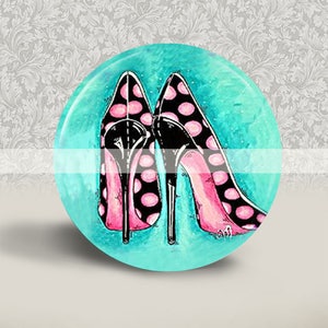 Puede incluir: Un par de zapatos negros de tacón alto con lunares rosas sobre un fondo turquesa.