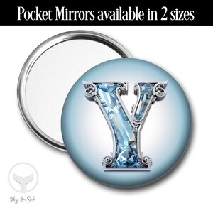 May include: A round pocket mirror with a blue background and a silver letter Y made of sparkling jewels. The mirror is available in two sizes.