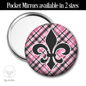 Puede incluir: Un espejo de bolsillo de cuadros rosa y negro con un diseño de flor de lis negra. Espejos de bolsillo disponibles en 2 tamaños.